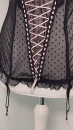 Black polka dot lace-up corset with a little bow