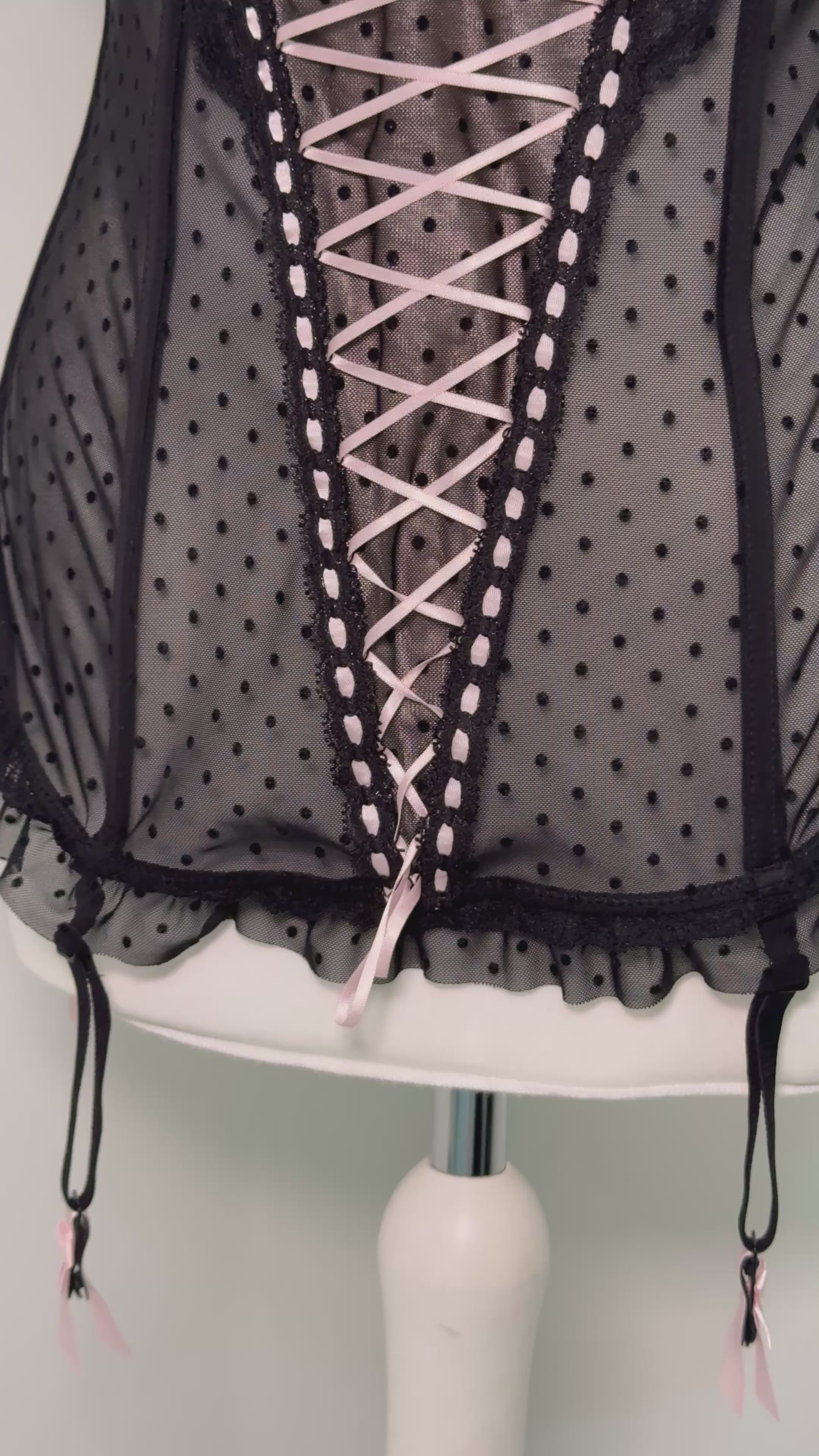 Black polka dot lace-up corset with a little bow